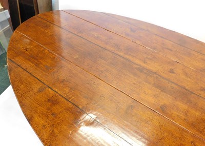 Lot 41 - A large oak oval drop-leaf wake table, with a...