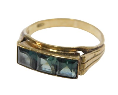 Lot 30 - A dress ring, set with three square cut green...