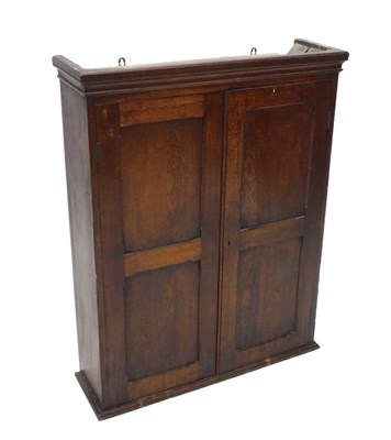 Lot 1122 - An 18thC oak panelled hanging cupboard, the...